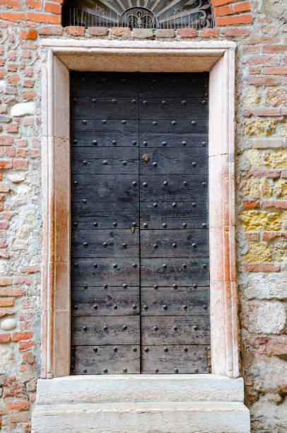 antigua puerta en casa de julieta en verona, italia - capulet fotografías e imágenes de stock