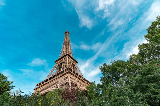 istock View on Eiffel Tower metal construction from bellow spring park trees in Paris, France 946568330