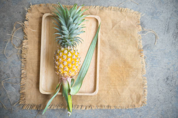 Whole pineapple fruit on grey concrete background