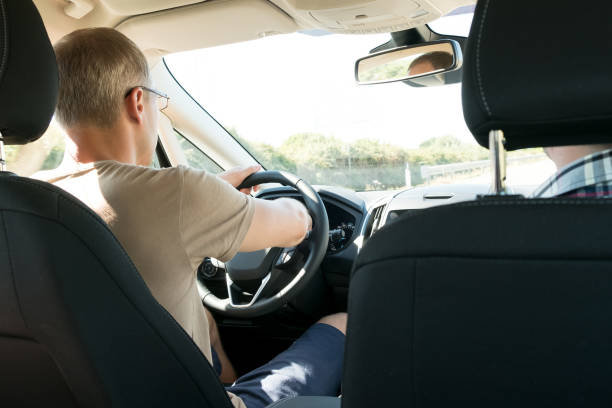 istock rear view, young man driving his car 946574248