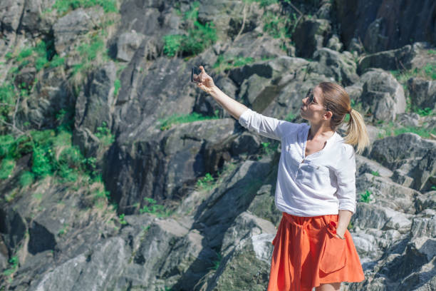 istock Young woman using smartphone on the lake in the springtime 946577418