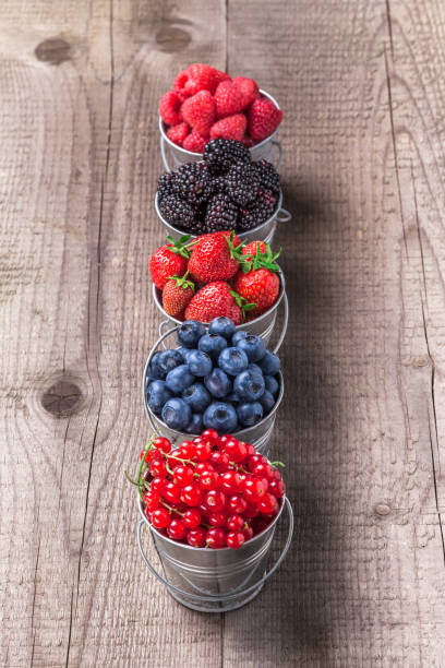 istock Berries assortment in five tin cans on rustic wooden table 946581606