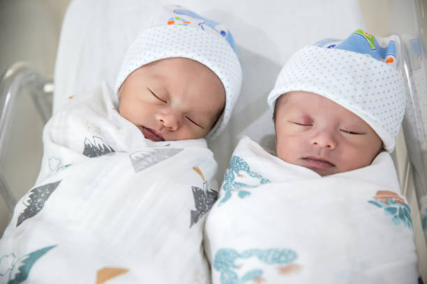 newborn twins sleeping.newborn babies twins sleep in bed. - baby lying down sleeping asian ethnicity imagens e fotografias de stock