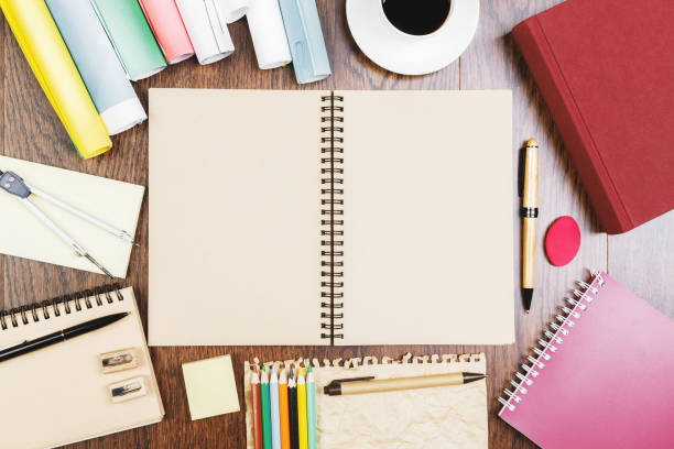 istock Wooden table top with notepad and coffee 946585570