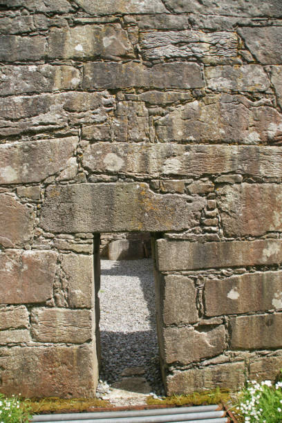 Lintelled Doorway of the St. Colman MacDuach Church, Inishmore Set in the village of Cill Mhuirbhigh on the Aran Island of Inishmore this church is dedicated to Saint Colman MacDuach Church, the 7th century founder of the monastery Cill Mac Duach (Kilmacduach) of Galway.  Entrance is through this primitive doorway, the stone across the top is called a lintel.  Inishmore, Aran Islands, County Galway, Ireland. michael stephen wills aran stock pictures, royalty-free photos & images