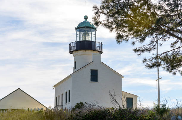 faro di point loma - una vista completa ravvicinata a basso angolo del faro di old point loma, secolare, in piedi su una collina contro il luminoso cielo pomeridiano di gennaio, nel cabrillo national monument, san diego, california, usa. - point cabrillo sea pacific ocean sky foto e immagini stock