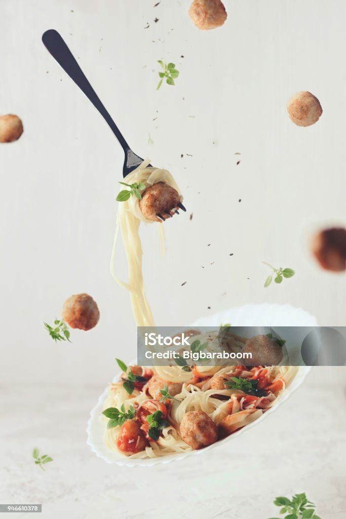 Comida volando. Levitación de fettuccine pasta con albóndigas, la salsa de tomate, la albahaca sobre fondo blanco - Foto de stock de Alimento libre de derechos