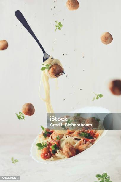 Photo libre de droit de Vol De Nourriture Lévitation De Fettuccine De Pâtes Avec Boulettes De Viande Sauce Tomate Basilic Sur Fond Blanc banque d'images et plus d'images libres de droit de Aliment