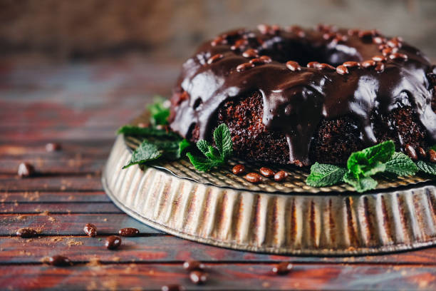 istock Sweet chocolate cake with cacao icing and decorated with mint and chocolate drops 946610578
