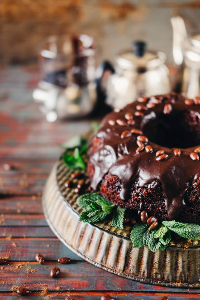 istock Sweet chocolate cake with cacao icing and decorated with mint and chocolate drops 946610596