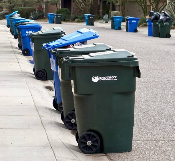 many green and blue bins for garbage and recycling out on street on collection day