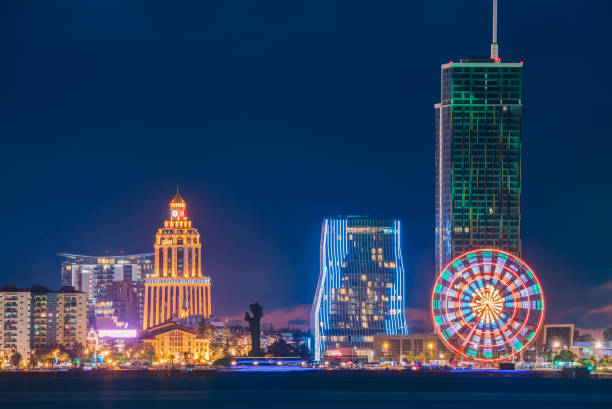 istock Batumi, Adjara, Georgia. Modern Architecture In Seafront Promenade. Miracle Park With Modern Buildings In Night Or Evening Illuminations Lights, Illuminated Resort Town Cityscape 946620744