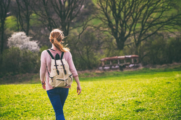 istock Woman with backpack hiking in countryside. 946621120