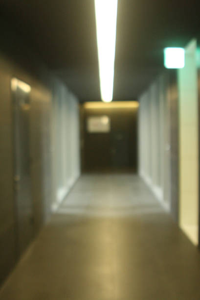 istock blurred hallway of grey modern office building 946624410