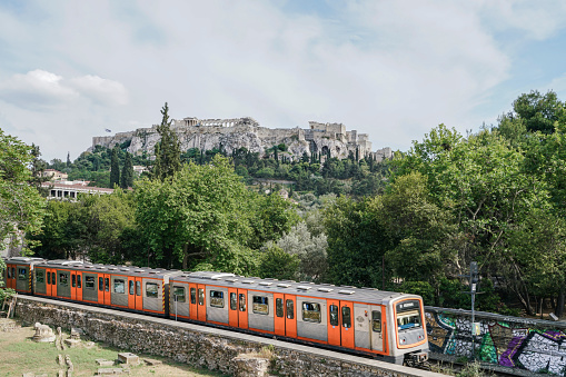 Athens, Greece - April 30, 2016; Train passes Monastiraki with Acropolis hill view in Athens, Greece