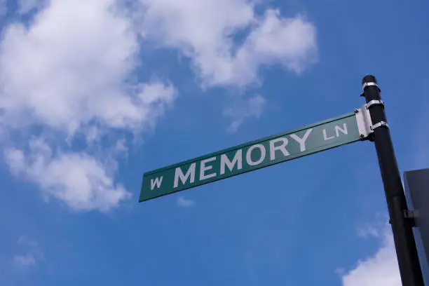 Memory Lane street sign against blue sky with white clouds