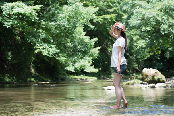le donne giapponesi si rilassano in un ruscello di montagna - denim shorts foto e immagini stock