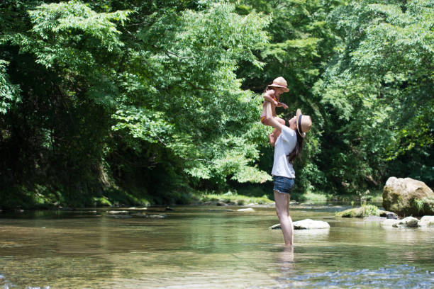 istock Mother and daughter playing in mountain stream 946632070