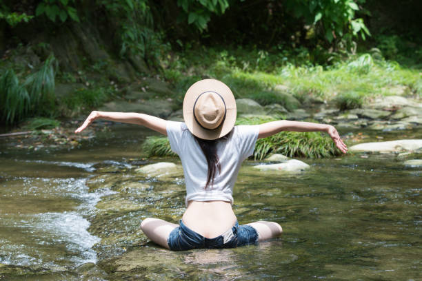 le donne giapponesi si rilassano in un ruscello di montagna - denim shorts foto e immagini stock