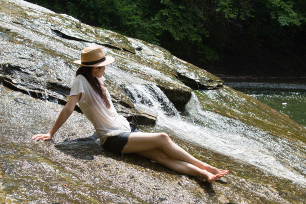 le donne giapponesi si rilassano in un ruscello di montagna - denim shorts foto e immagini stock