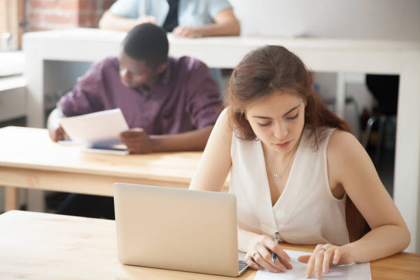 istock Female worker working with paperwork in coworking office 946637060
