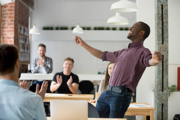 Exited african american dancing victory dance in office