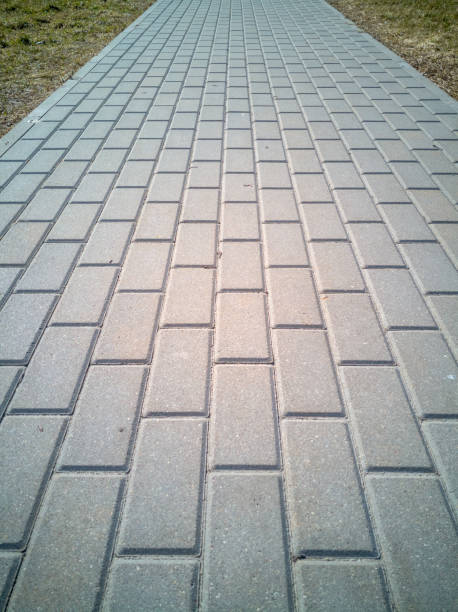 istock Straight gray brick pavement that leads you ahead 946676600