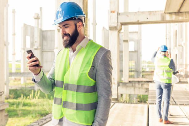 istock Young male architect or businessman using a smartphone on a construction site. 946679482