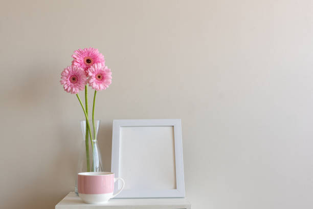 istock Tall pink gerberas with blank frame and pink mug 946692572