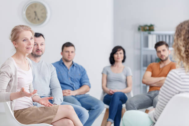 Therapist discussing problems Female therapist discussing problems with her patients during a support group meeting alcoholics anonymous photos stock pictures, royalty-free photos & images