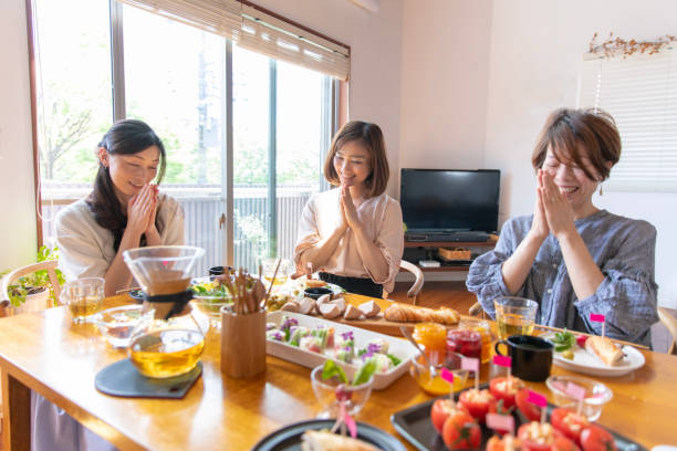 istock Female friends praying before eating lunch 946710798