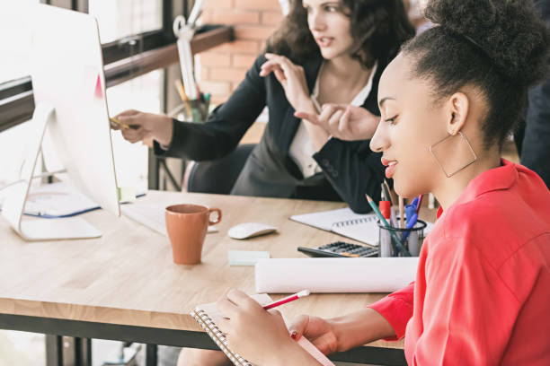 istock Black business woman taking notes at office meeting 946710994