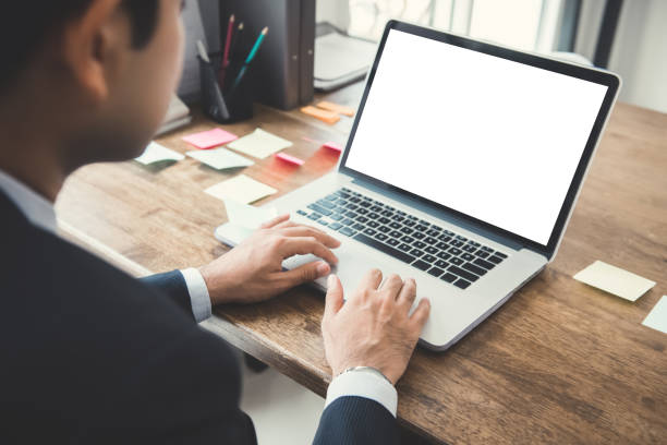 istock Businessman working on laptop computer with empty white screen at his desk 946711000