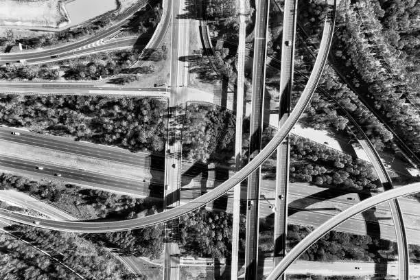Light horse interchange between M4 and M7 motorways in Sydney west - the lagest in New South Wales and Greater Sydney. Aerial black white top down view over the middle of intersection.
