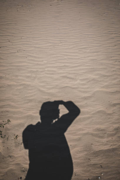 silhouette shadow of photographer on sand beach