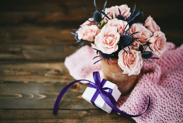 Handmade Mother's Day bouquet with pink roses and gift in rustic setting