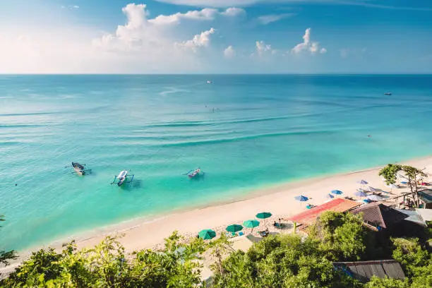 Tropical blue ocean, sandy beach and boats in Indonesia, Bali