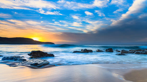 istock Blue Sunrise Seascape with Rocks and Clouds 946757554