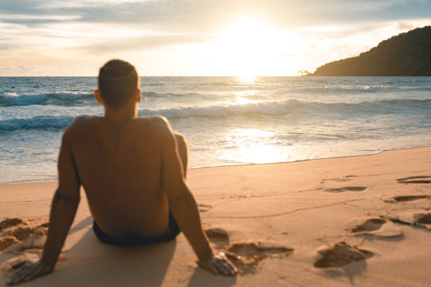 istock Young handsome man siting at the lazy beach 946757988