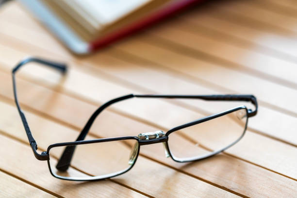istock Open book and glasses on wooden table close 946759990