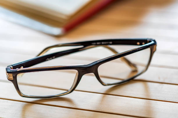 istock Open book and glasses on wooden table close 946760028