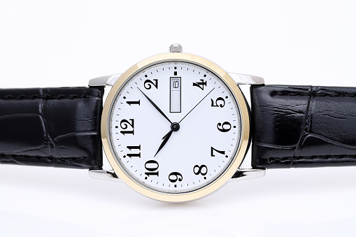 close up of wrist watch with leather strap on white background