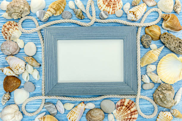istock frame decoration on blue background with seashells, stones and marine rope 946766354