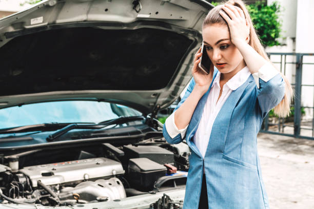 istock Woman calling for assistance with broken down car engine on street 946766506