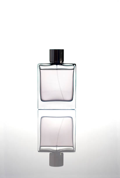 Bottle of clear perfume reflecting off the floor stock photo