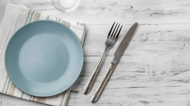 Empty grey plate on light wooden background