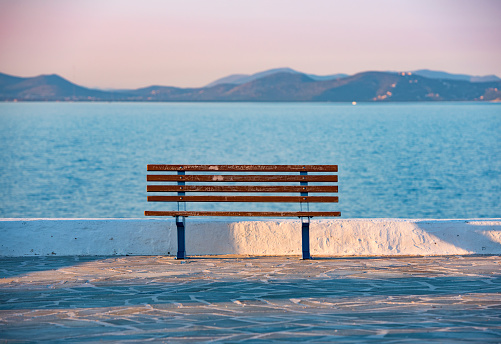 sunset and bench in Rafina city with Aegean sea at the background.