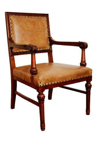 antique wooden armchair on the white background, seat and backrest covered with leather