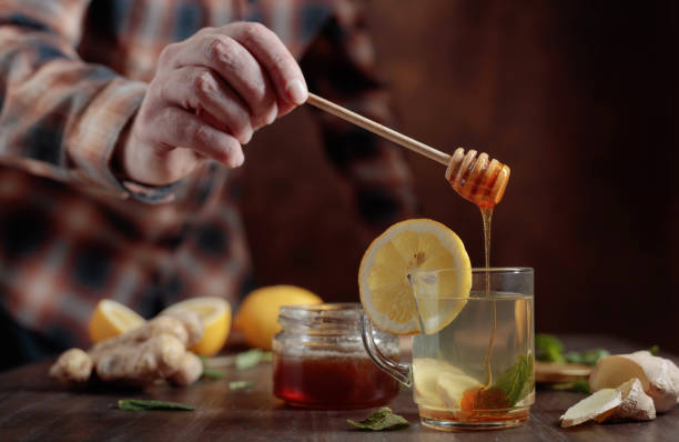 istock Ginger tea with honey , lemon and mint on old wooden table . 946798394