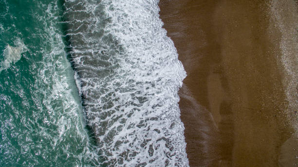 istock Aerial view waves break on white sand beach. 946802312